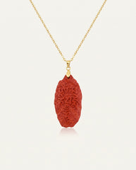 Six Character Mantra cinnabar necklace on gold chain, ivory studio background