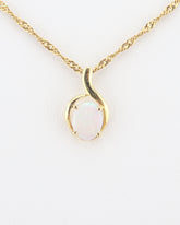 Handmade Australian solid Coober Pedy opal pendant necklace in 18k gold, centered studio shot