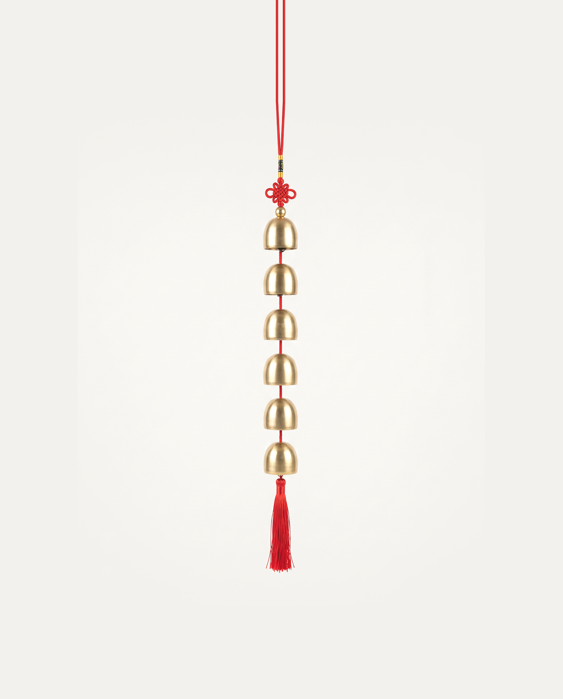 Brass Bell Hanging Charm, six brass bells on a red cord with tassel, studio photo