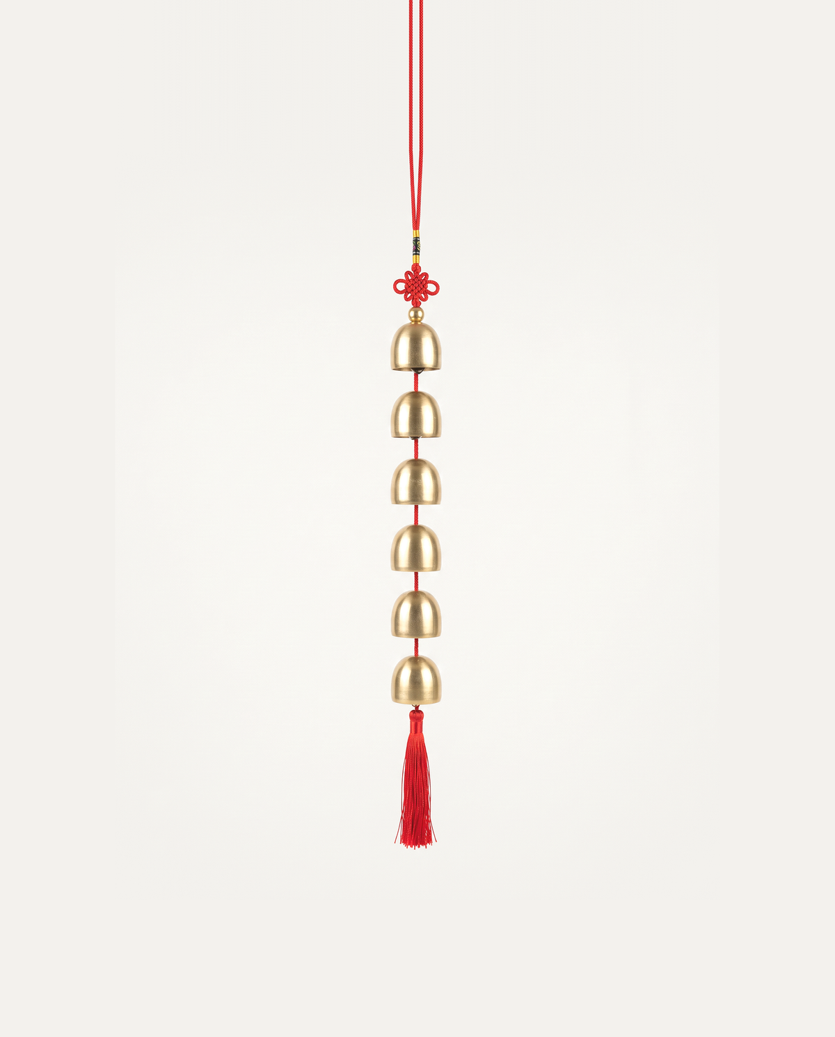 Brass Bell Hanging Charm, six brass bells on a red cord with tassel, studio photo