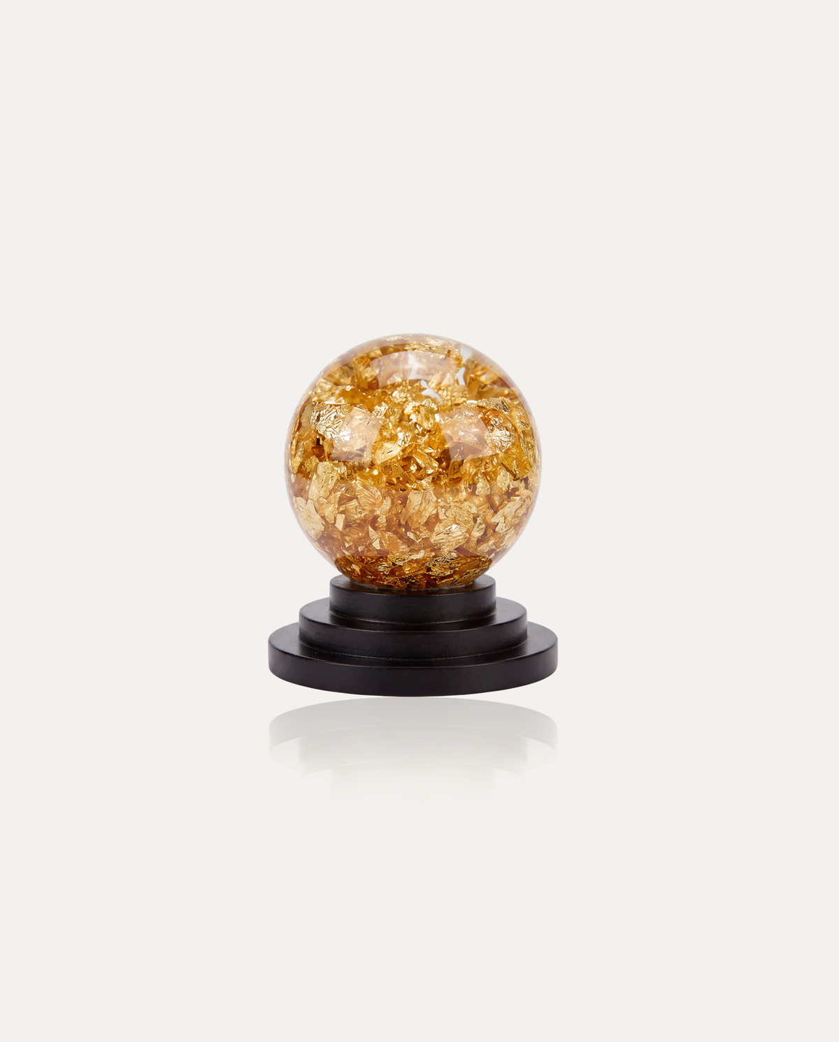 Gold Leaf Feng Shui Ball on black wooden stand, studio photo