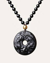 Twin Pixiu obsidian pendant necklace on ivory studio background