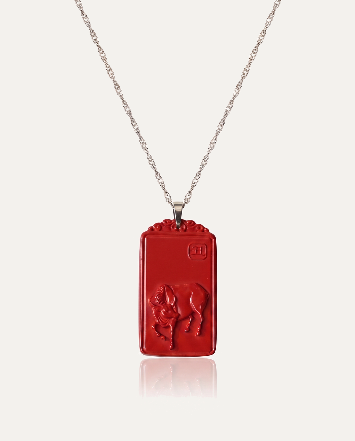 Ox zodiac cinnabar pendant necklace silver chain on ivory background