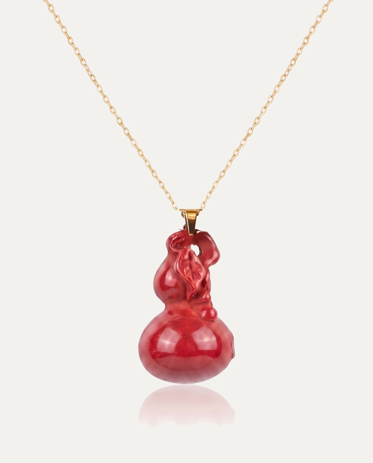Smooth hulu cinnabar pendant necklace gold chain on ivory background