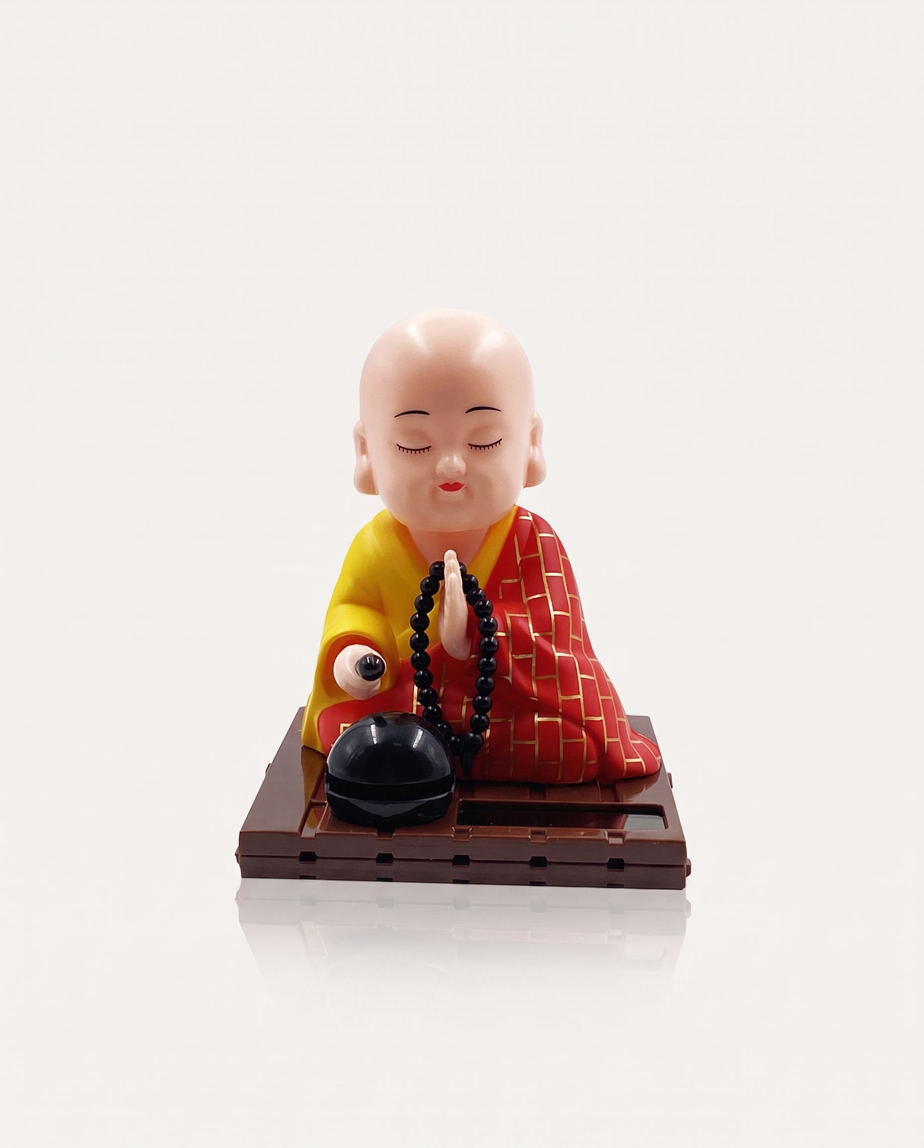 Solar Nodding Monk kneeling with mala on solar base
