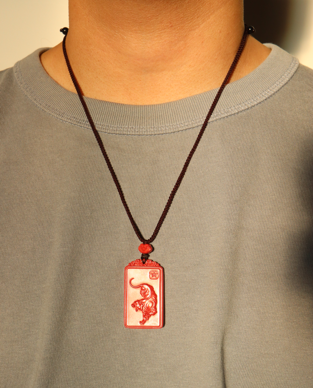 Model wearing the zodiac cinnabar pendant necklace on the adjustable braided cord